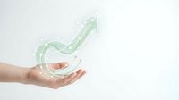 Cropped hand holding glowing upward arrow symbol representing financial growth, business success, and positive market trends for corporate presentations.