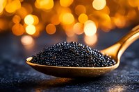 Black caviar on golden spoon with warm bokeh lights background for luxury dining and gourmet food concepts.