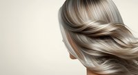 Young woman with long, flowing silver and blonde highlighted hair styled in soft waves, shown in profile against a neutral background. Suitable for hair care, beauty products, salon services, and cosmetic advertising.