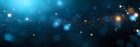 Magical glowing blue and gold bokeh lights scattered on dark background create dreamy atmospheric effect for festive designs and holiday backgrounds.