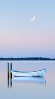 Serene white wooden boat moored at dock posts on calm lake water at dusk, with crescent moon in pastel pink and blue sky, reflecting peaceful atmosphere.