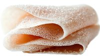 Crepes dusted with powdered sugar, folded and stacked, ready for serving as a sweet dessert or breakfast treat.