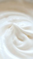 Creamy white swirled texture with smooth flowing patterns creating luxurious abstract background for skincare and beauty product designs.