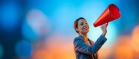 Professional African American businesswoman speaking through red megaphone against vibrant blue and orange bokeh background for marketing campaigns.