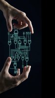 Two hands holding glowing green circuit board schematic with interconnected pathways and microchip components on dark background, representing technology innovation and digital system design.