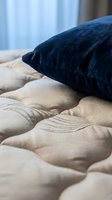 Stacked navy and beige decorative pillows on bed with soft natural light, showcasing textile comfort and home interior design for bedroom styling.