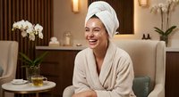 Young woman in bathrobe and towel relaxing at luxury spa resort, enjoying wellness treatment and self-care routine in elegant hotel room interior.