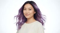 Young Asian woman with purple ombre hair wearing white sweater smiling at camera against light background for beauty and lifestyle content.