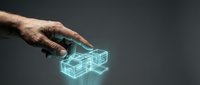 Male hand with medium skin tone reaching toward glowing turquoise wireframe cube structure on dark background, representing digital technology, innovation, and virtual interaction for design projects.