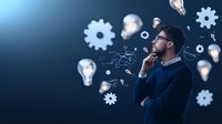 Young Asian businessman in glasses thinking thoughtfully with floating light bulbs and gears, representing innovation and creative problem solving process.