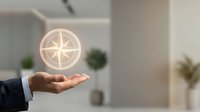 Professional businessman hand presenting glowing compass symbol in modern office environment representing guidance, direction and business navigation.