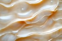 Macro closeup of lustrous pearl shell surface with soft ivory and golden wave layers, showcasing natural organic texture and iridescent sheen.