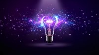 Glowing light bulb with purple and blue energy particles bursting outward on dark background, representing innovation, creativity, and bright ideas for business and technology concepts.
