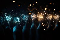 Silhouetted crowd holding glowing phone flashlights at concert or event, creating magical atmosphere with blue and golden bokeh lights against dark background.