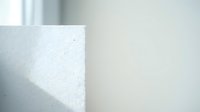 Minimalist white textured wall corner with soft natural lighting and shadow creating clean geometric architectural detail for modern interior design.