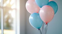 Festive pink and blue helium balloons floating against soft blurred background, creating dreamy party atmosphere for gender reveal, baby shower or celebration.