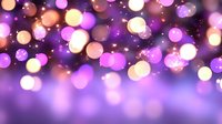 Magical purple and gold bokeh lights creating dreamy abstract background with glowing defocused circles and sparkles for festive or romantic designs.