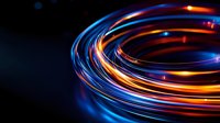 Glowing spiral light trails in orange and blue colors against dark background create dynamic motion effect for technology and communication designs.