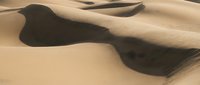 Abstract desert landscape with flowing sand dunes and dramatic shadows creating natural patterns and textures for minimalist design projects.