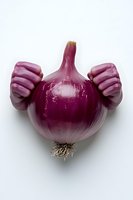 Fresh red onion with creative hands emerging from sides against white background, suggesting strength and healthy eating concept. Isolated food photography.