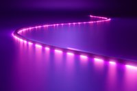 Curved line of glowing pink LED lights creating path on purple surface with reflection, modern minimalist design for technology and entertainment backgrounds.