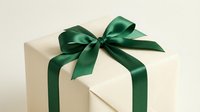 Elegant cream gift box with luxurious emerald green satin ribbon bow for special occasions, holidays, celebrations and festive present wrapping.
