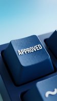 Closeup of blue keyboard key with approved text stamped on top, symbolizing acceptance, authorization, and confirmation for business applications and digital approval processes.