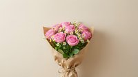 Pink roses bouquet with baby's breath wrapped in kraft paper against neutral background for romantic gifts and special occasions.