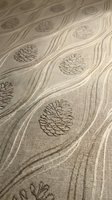 Elegant beige fabric with embroidered pinecone pattern and flowing curved lines, natural textile design for upholstery and home decor projects.