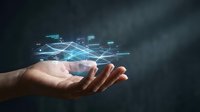 Hand holding futuristic holographic network connections with glowing blue digital lines and data nodes floating above palm against dark background.