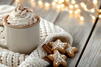 Hot chocolate with whipped cream and cinnamon in white mug, gingerbread cookies and knitted sweater on wooden table with warm lights for holiday beverage and winter celebration designs.