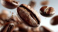 Roasted coffee beans falling with motion blur and scattered grounds creating dynamic splash effect for cafe branding and beverage marketing materials.