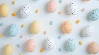 Colorful Easter eggs in pastel colors with dots pattern scattered on white background. Festive spring holiday composition with candy decorations.