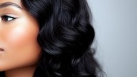 Young Asian woman with glossy black wavy hair and flawless glowing skin shown in profile view against neutral background, beauty and haircare concept.
