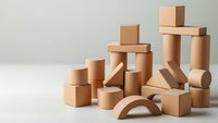 Natural wooden building blocks set with geometric shapes including cubes, cylinders and arches arranged on neutral background for educational play.