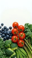 Fresh organic vegetables and fruits including cherry tomatoes, blueberries, broccoli, asparagus and leafy greens arranged on white background for healthy eating.