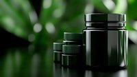 Dark green cosmetic jars on blurred natural background with bokeh effect. Premium packaging mockup for organic skincare and beauty products.