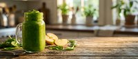 Fresh green smoothie in mason jar with spinach leaves and banana on wooden kitchen counter for healthy breakfast and detox lifestyle.