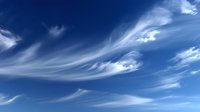Dramatic wispy cirrus clouds stretching across vibrant blue sky, creating ethereal patterns and movement in high atmosphere.