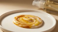 Drizzle of golden honey swirled on white plate with oil bottle, food styling for culinary and recipe content.