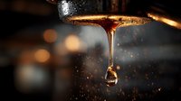 Golden honey dripping from spoon with suspended droplet against dark blurred background, capturing sweet viscous flow in warm ambient lighting.
