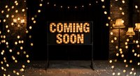 Illuminated coming soon sign with warm golden string lights creating magical bokeh atmosphere for business announcements and promotional campaigns.