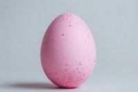 Pink speckled Easter egg with delicate dots on clean white background, isolated for spring holiday designs and seasonal decorations.