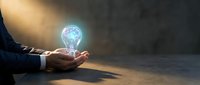 Business professional holding glowing lightbulb with network connections symbolizing innovation, creativity, and digital transformation in corporate environment.