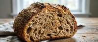 Sliced loaf of artisan sourdough bread with crispy crust and airy crumb structure, displayed on wooden surface for bakery, food, and culinary use.