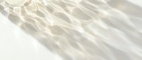 Translucent fabric with delicate wrinkles and soft shadows casting across white surface, suitable for textile, fashion, and design backgrounds.