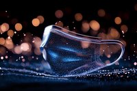 Medical face mask on dark background with bokeh lights and water drops, dramatic lighting creates mysterious atmosphere for healthcare concept.