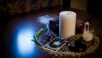 Mystical tarot cards with burning candle and crystal creating atmospheric fortune telling scene for spiritual guidance and divination practices.