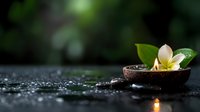 Glowing plumeria flower in wooden bowl with water drops and zen stones on dark background, creating peaceful spa atmosphere with soft candlelight reflection.