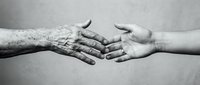 Young and elderly hands reaching toward each other in black and white, symbolizing intergenerational connection, care, and human bond across age groups.